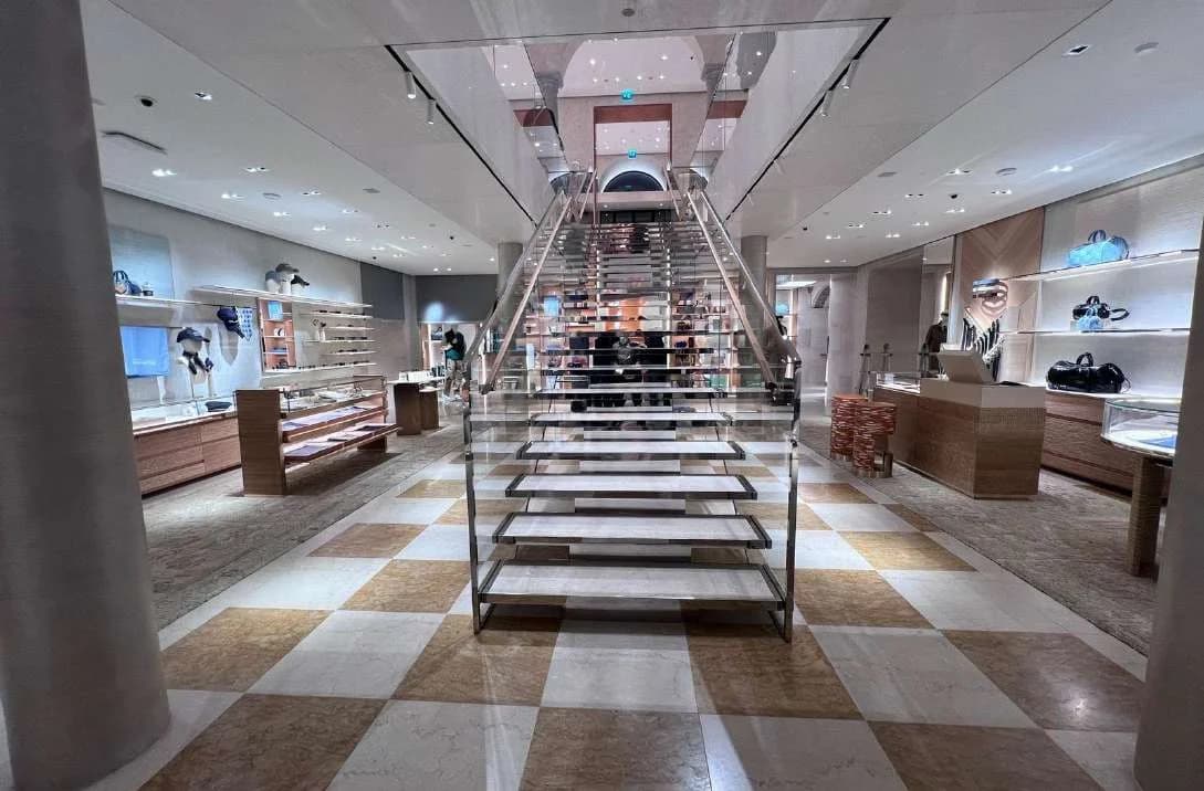 Monumental marble staircase above a checkerboard marble floor in the Louis Vuitton Milan boutique