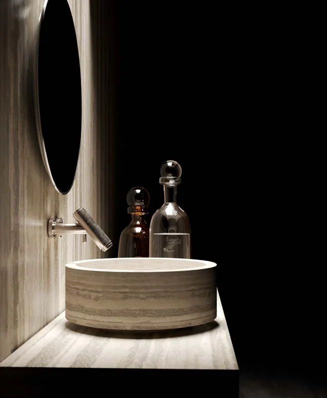 Sculptural travertine basin on a dark background