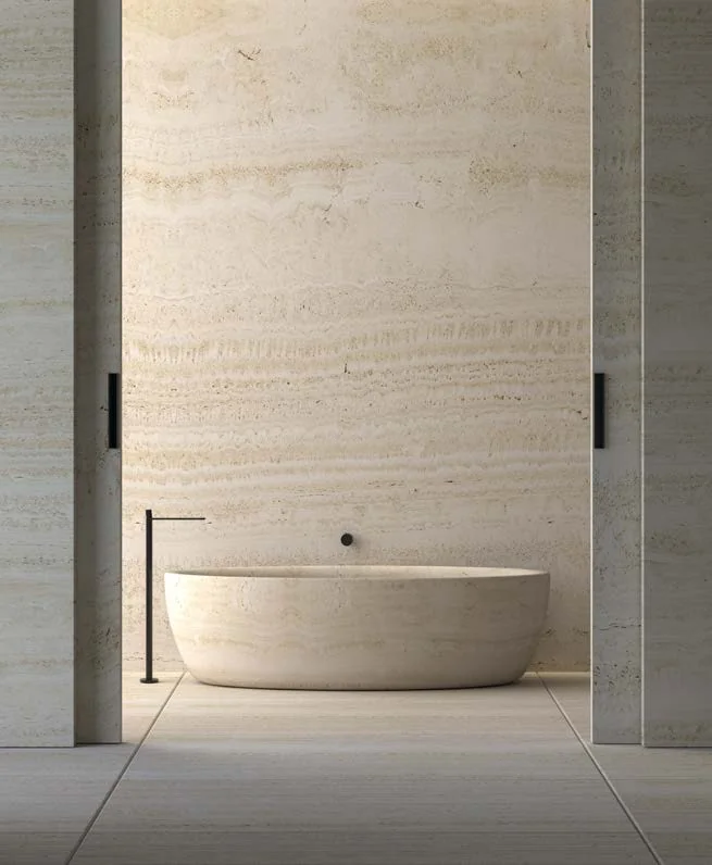 Bathroom with a travertine wall and a freestanding tub
