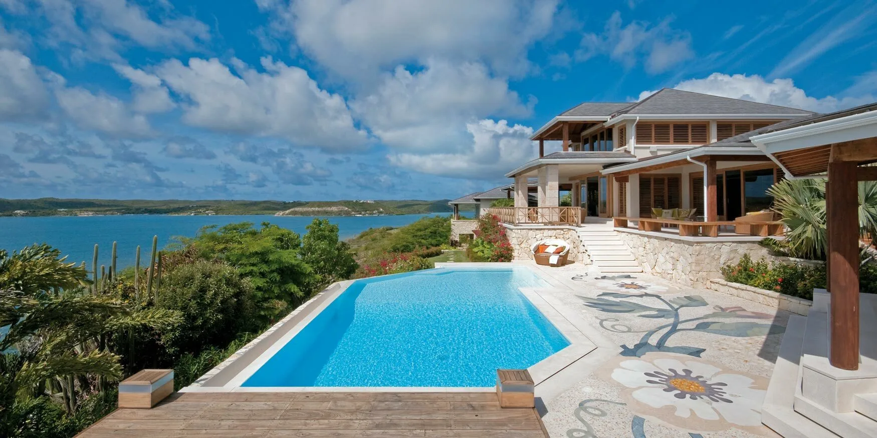 Caribbean villa with an infinity pool and a floral marble mosaic terrace overlooking the bay