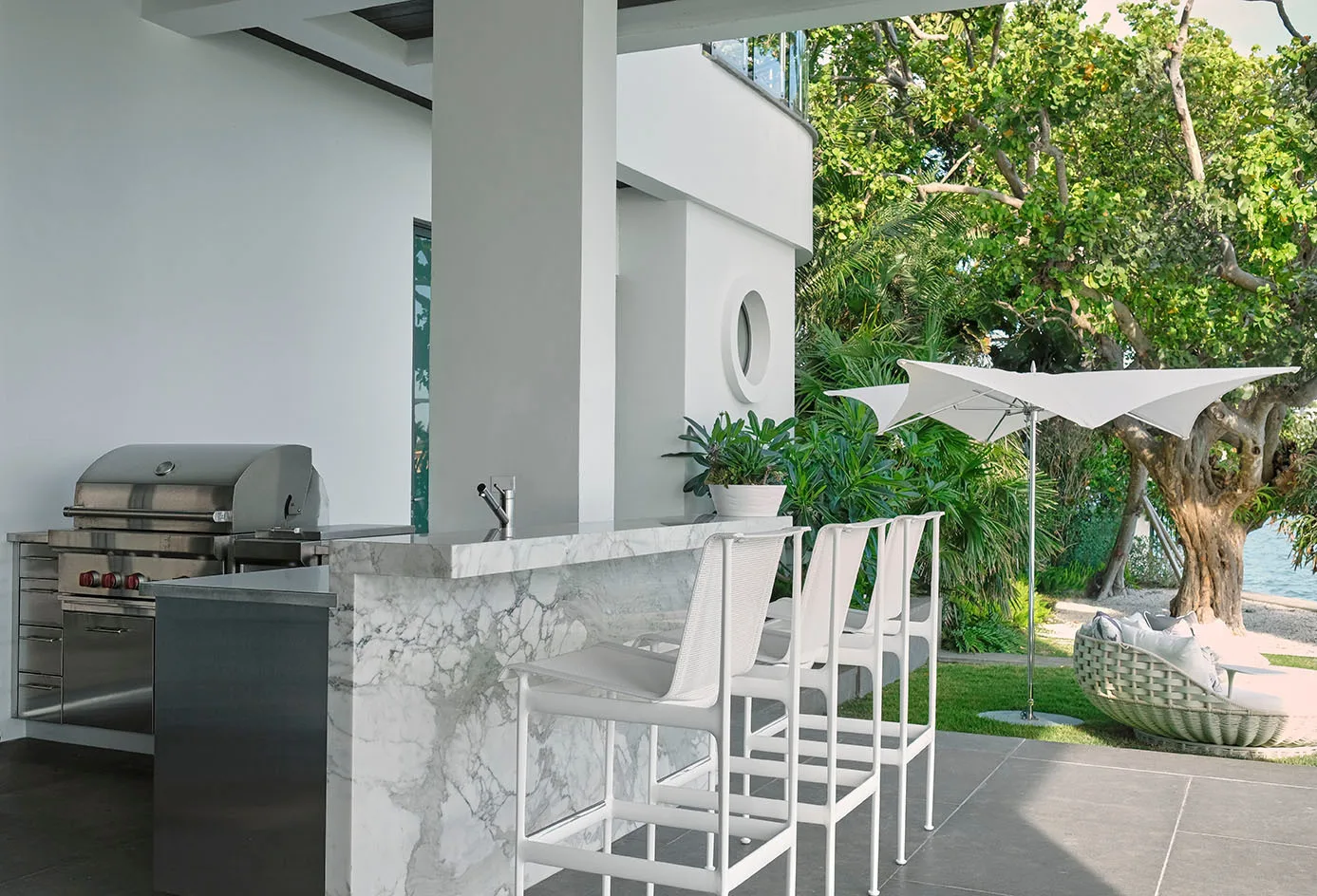 Waterfront outdoor kitchen with a marble bar and terrazzo terrace