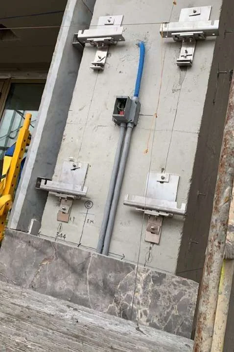 Metal anchor brackets fixed to a concrete wall for stone panel mounting