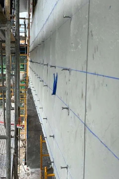 Concrete wall prepared with anchor points and marking tape