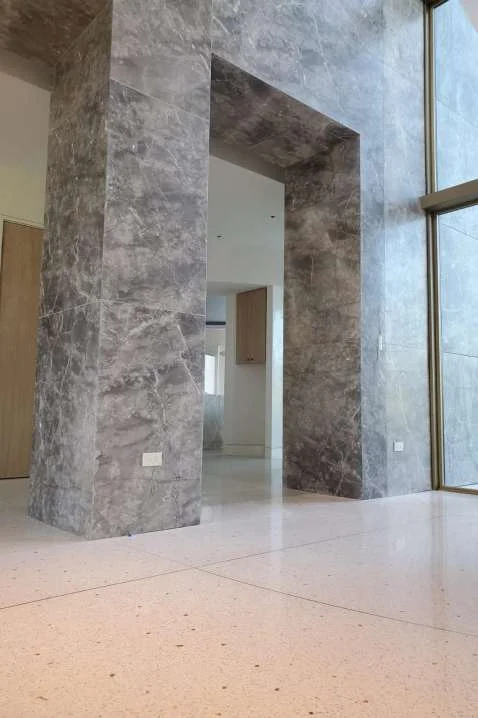 Full-height grey stone columns and portals in the double-height living area