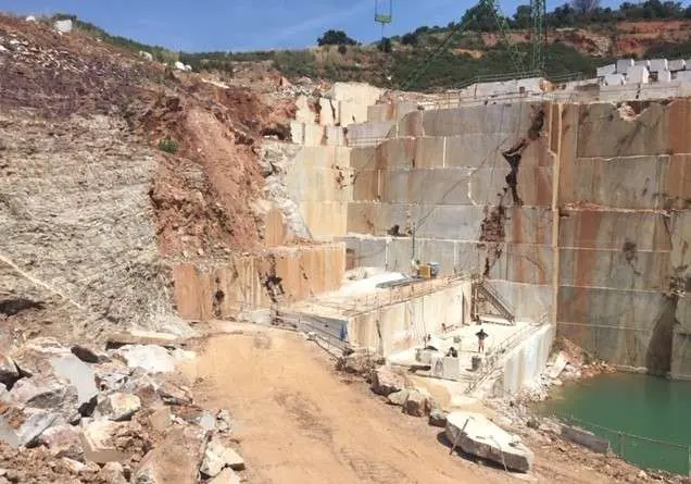 Open quarry pit with a water basin at the bottom
