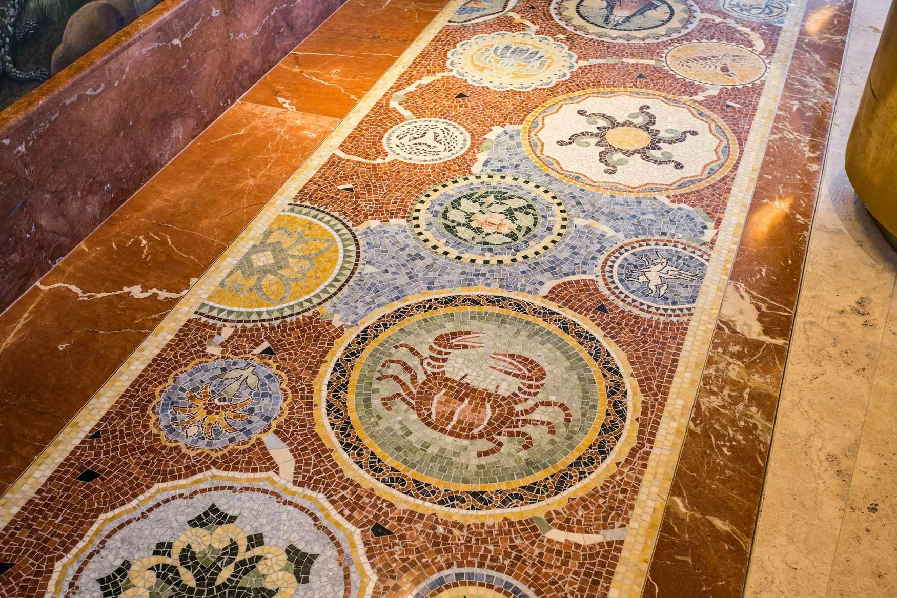 Roman-style marble mosaic floor with zodiac and marine medallions at Hotel Faena