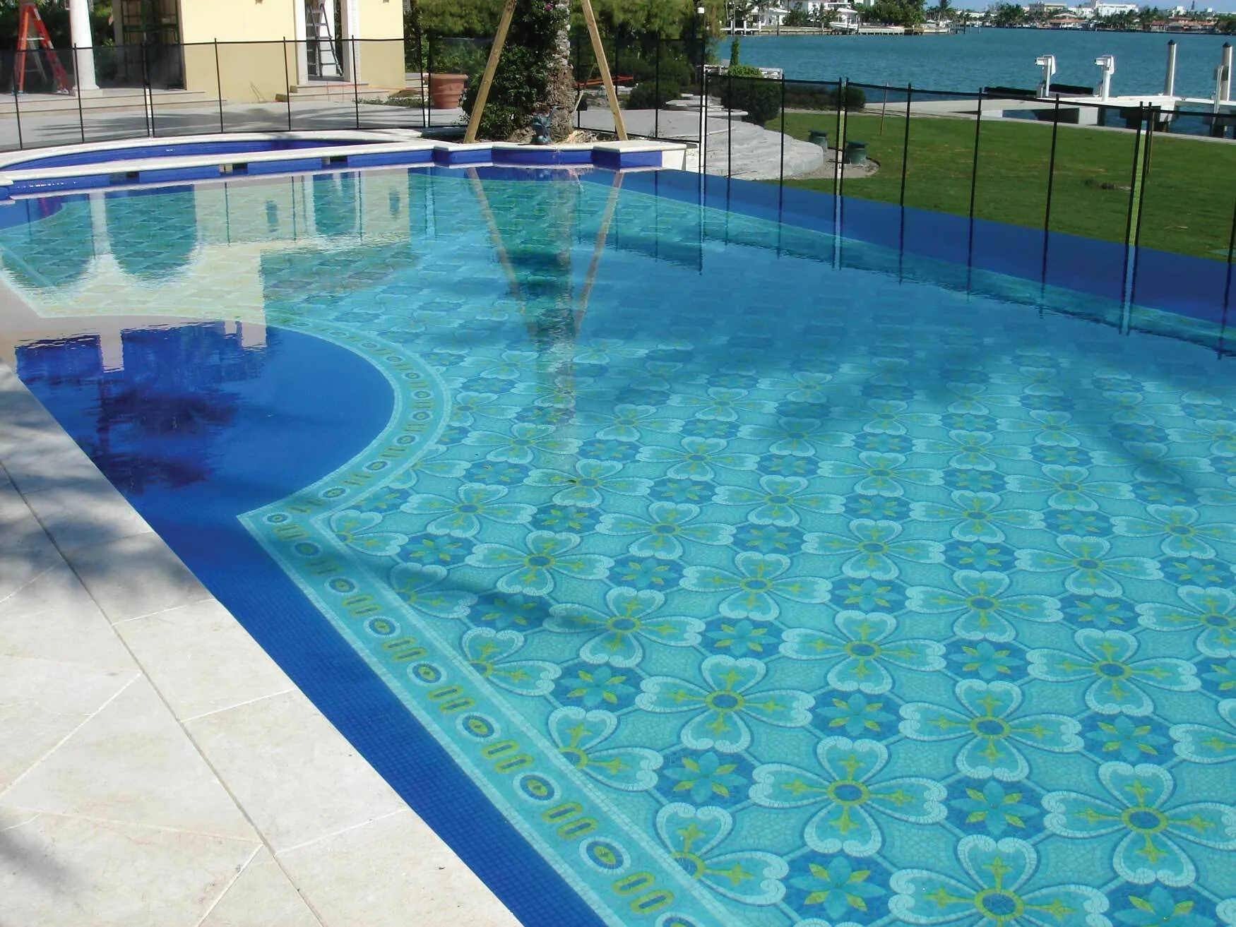 Waterfront swimming pool with a turquoise floral mosaic floor on Indian Creek Island