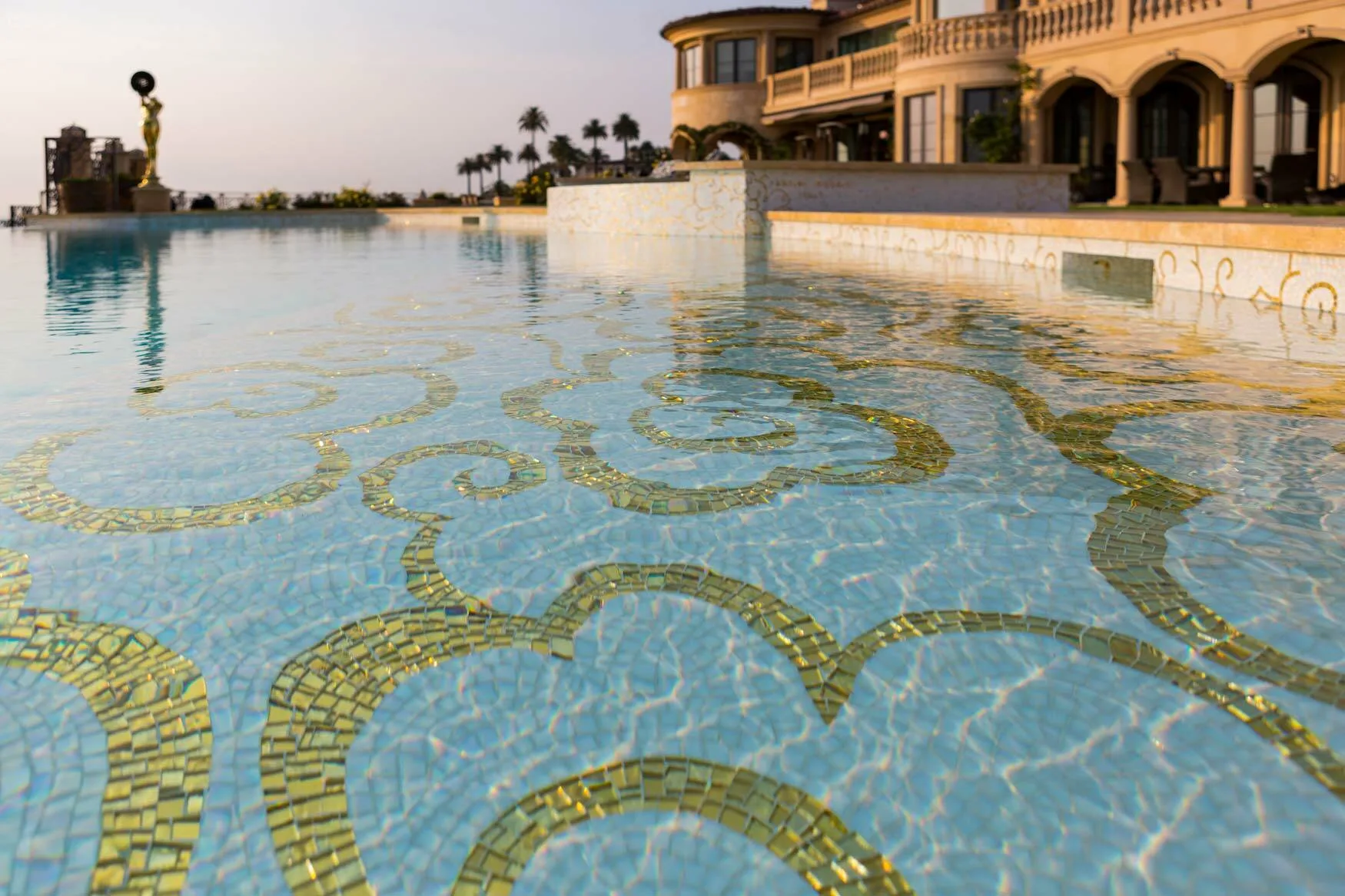 Gold scroll mosaic seen through the clear water of the pool