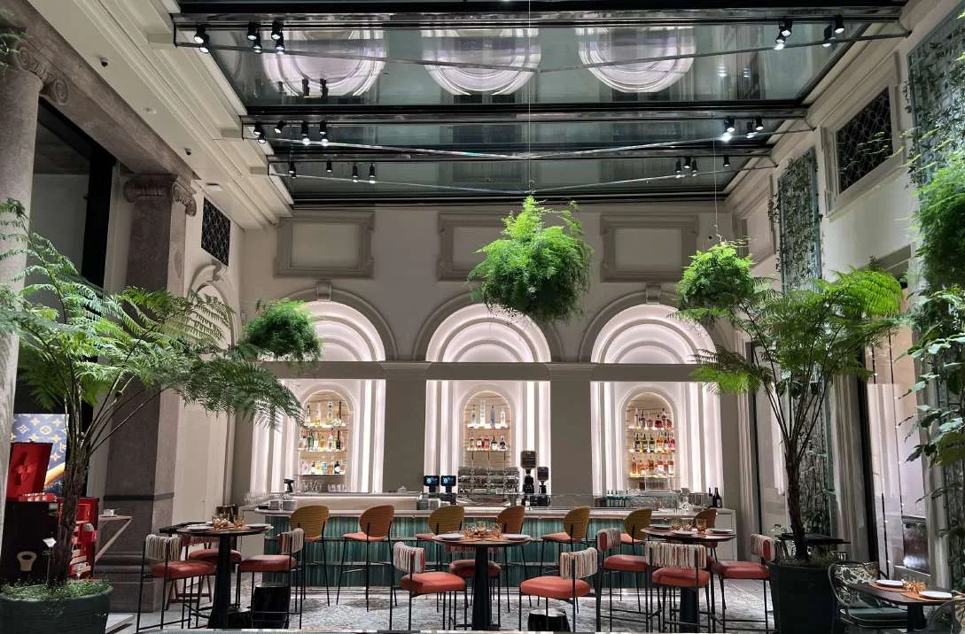 Restaurant in a glazed courtyard with a mosaic floor and plants