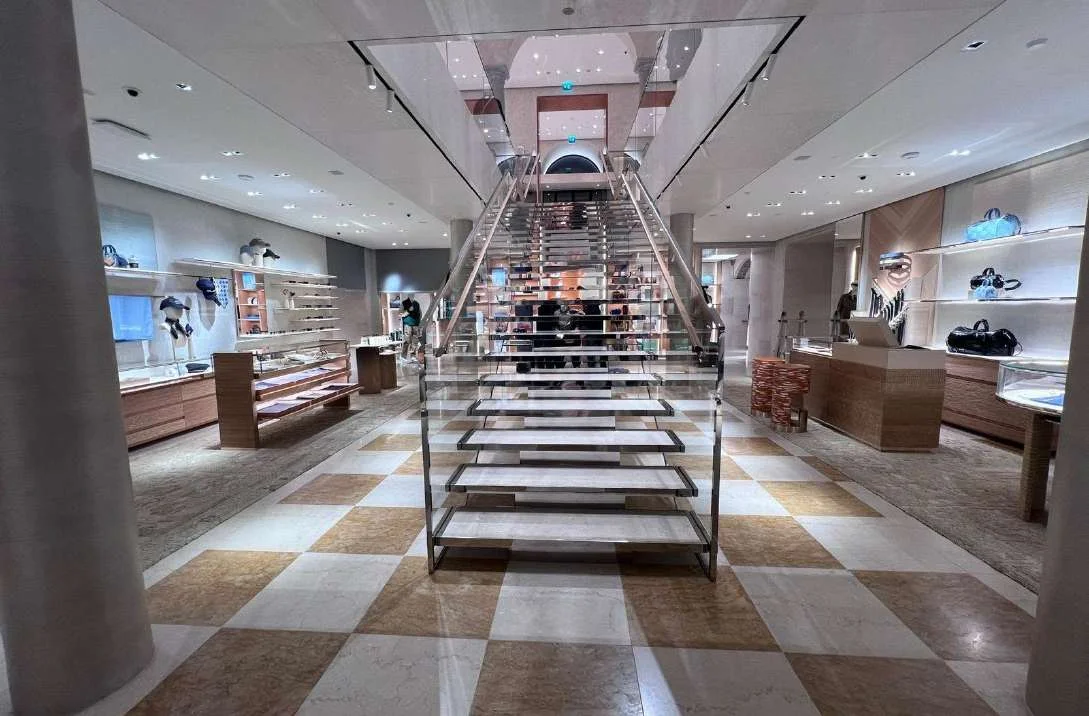 Monumental marble staircase above a checkerboard marble floor in the Louis Vuitton Milan boutique