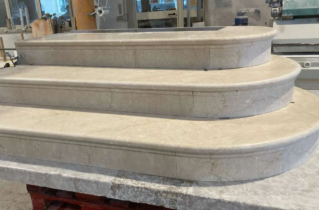 Curved marble staircase treads under fabrication in the workshop