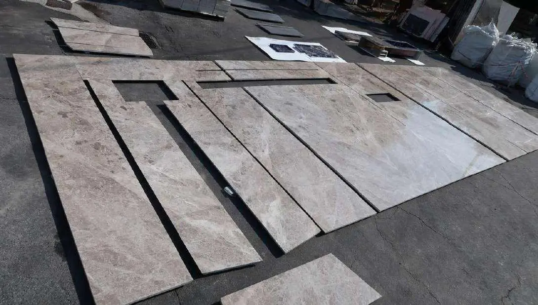 Grey marble floor panels laid out for inspection