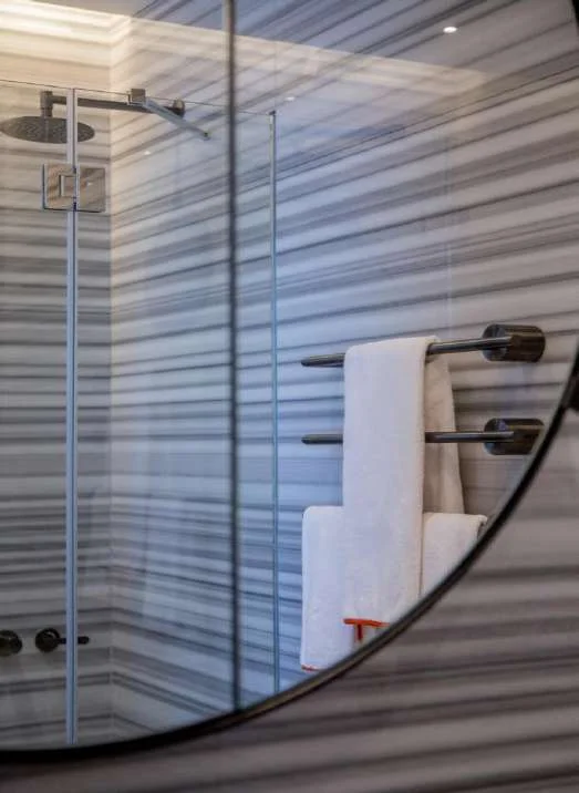 Fluted Striato Olimpico wall cladding with a glass shower screen