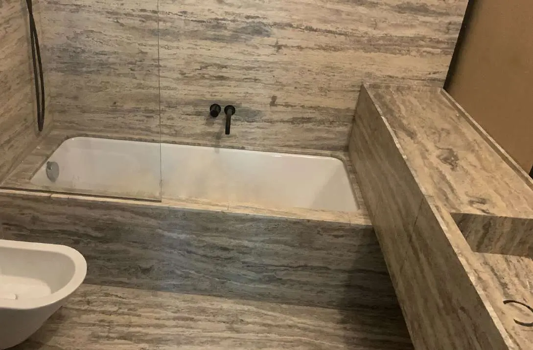 Walk-in shower lined in Travertino Silver with a ceiling rain head