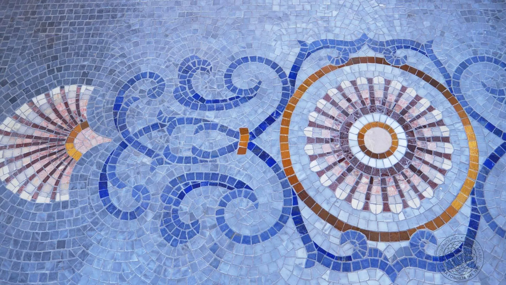 Close-up of the blue mosaic pool floor with floral and scroll motifs