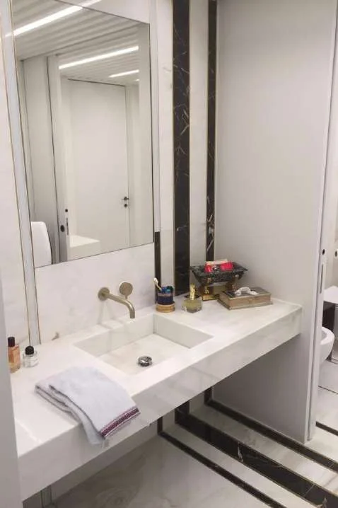 Bathroom with a marble vanity, mirror and marble wall cladding