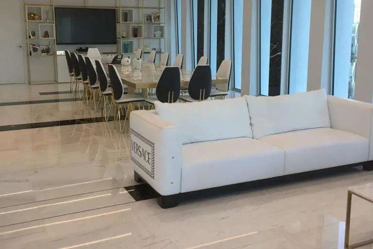 Meeting room with a long table, chairs and a marble floor beside a glazed wall