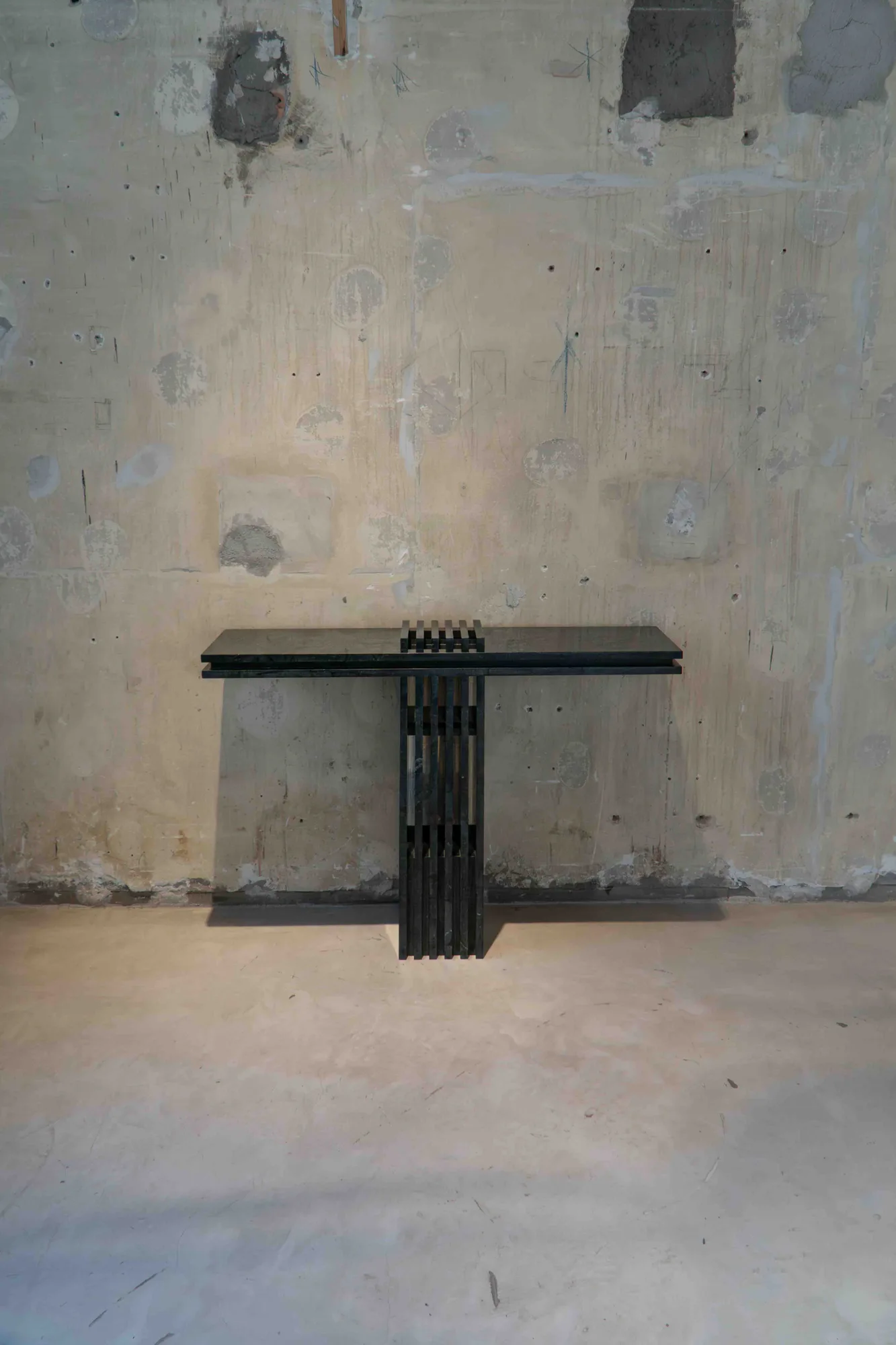 Dark marble console with a base of vertical slabs